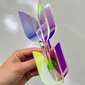 Schimmernde Tulpe aus irisierendem Acryl in einer Hand.